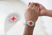 Arm mit Hausnotrufknopf am Handgelenk